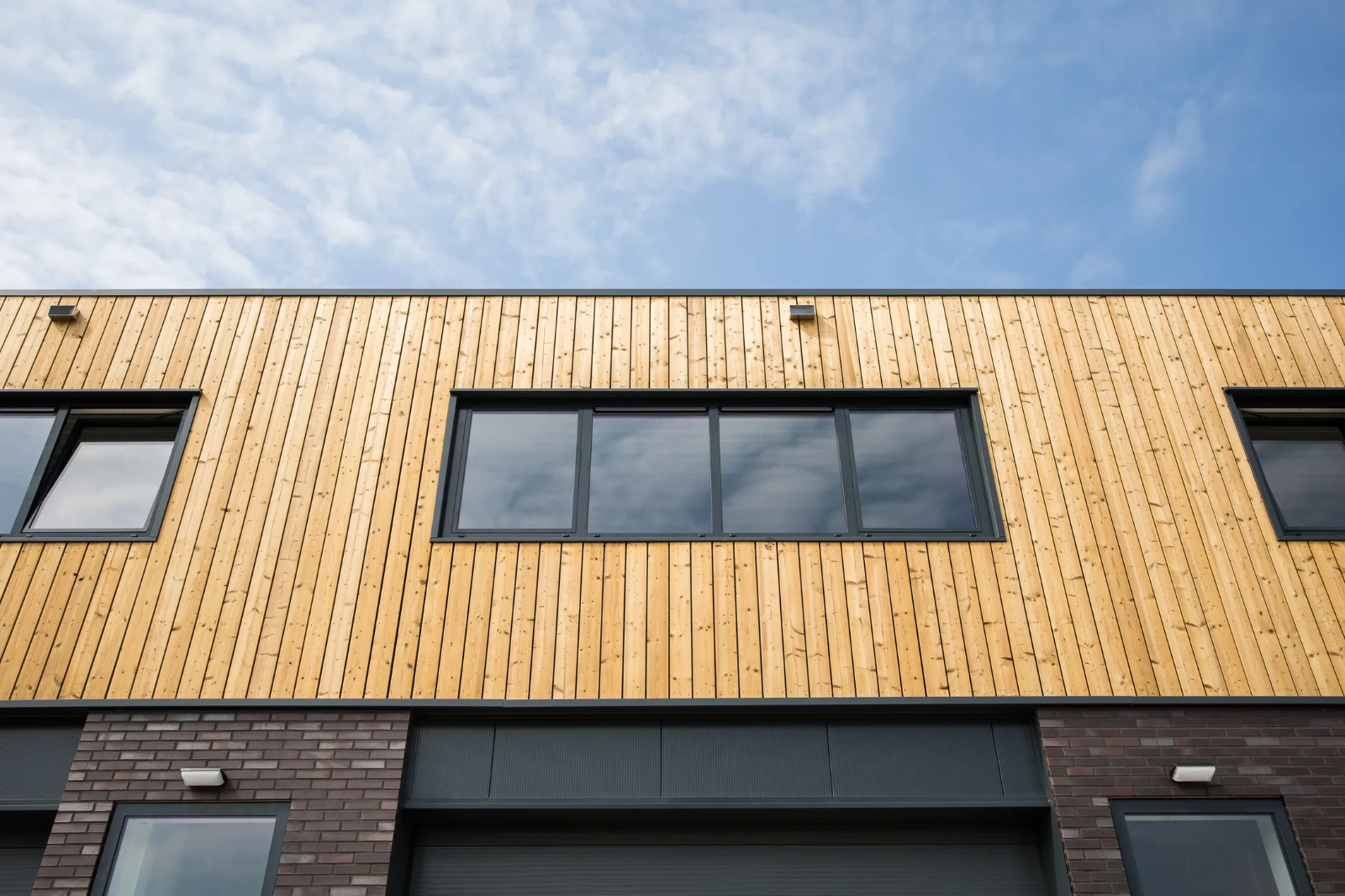 Modern bedrijfsgebouw met hout en donker metselwerk